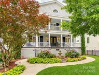Charming two-story home with a fountain, landscaped yard, and inviting double-decker front porch at 1600 Princeton Ave, Charlotte, NC 28209