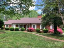 Charming red brick home with lush landscaping, rounded bushes, and vibrant pink azaleas in the front yard at 1614 Statesville Blvd, Salisbury, NC 28144