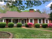 Charming brick home with lush landscaping and a well-manicured lawn creates a welcoming curb appeal at 1614 Statesville Blvd, Salisbury, NC 28144