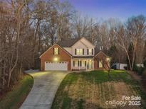 Charming two-story home with a brick facade, manicured lawn, and a welcoming front porch at 1730 Eden Glen Dr, Dallas, NC 28034