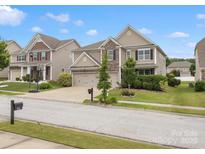 Charming two-story home boasts stone accents, a two-car garage, lush landscaping, and a well-maintained front yard at 1810 Kerwick Ct, Lancaster, SC 29720