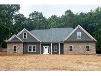 New construction home with a combination of stone and siding, white trim, and newly seeded lawn at 209 Stafford Estates Dr, Salisbury, NC 28146