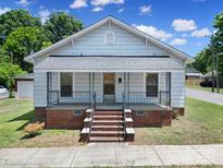 Charming single Gathering home featuring a brick foundation and a quaint front porch with rod iron railings at 220 Parker Ave, Mooresville, NC 28115