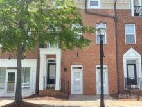 Charming brick townhome with inviting entrance and mature tree in the front at 2411 Bonterra Blvd, Indian Trail, NC 28079