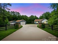 Charming home with long driveway, lush lawn, and stone accents near trees, offering curb appeal and privacy at 2949 Anderson Burgess Rd, Sharon, SC 29742