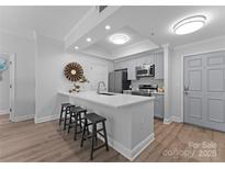 Bright kitchen features a quartz countertop island with barstool seating and stainless steel appliances at 300 W Fifth St # 509, Charlotte, NC 28202