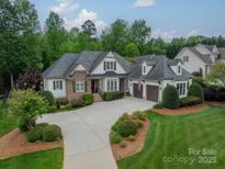 A charming, landscaped two-story home boasts a three-car garage and welcoming driveway at 3500 Maple Wood Dr, Denver, NC 28037