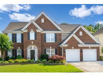 Beautiful brick home with a manicured lawn and a two-car garage, under a sunny blue sky at 5046 Cressingham Dr, Fort Mill, SC 29707