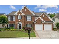 Beautiful two-story brick home featuring a manicured lawn and a two-car garage at 5046 Cressingham Dr, Fort Mill, SC 29707