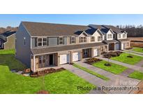 New townhomes featuring a mix of siding and brick, attached garages, and nicely manicured lawns at 5142 Tommy Ln # 1202, Stanley, NC 28164