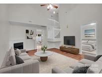 Bright living room with fireplace, high ceilings, and an open view to the staircase at 5237 Ficus Tree Ln, Charlotte, NC 28215