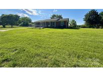 Charming brick home featuring a well maintained lawn and a convenient access ramp at 5420 Harkey Rd, Waxhaw, NC 28173