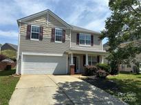 Charming two-story home with an attached garage and a well-manicured front yard at 6614 Burkwood Ct, Harrisburg, NC 28075