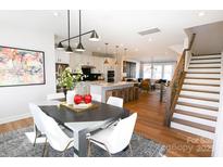 Bright dining room area with gray table, white chairs, and an open view to the kitchen and living room at 8044 Cedarsmith Ct, Charlotte, NC 28217