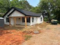 Newly built home with white siding, black roof, and wooden porch columns at 807 S Bostian St, China Grove, NC 28023