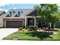 Charming single-Gathering home featuring a well-maintained front yard, stone accents, and an attached two-car garage at 9062 Treetop Nw Way, Concord, NC 28027