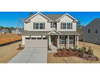 Charming two-story home with a manicured lawn, a two-car garage, and a welcoming front porch at 1048 Waxhaw Crossing Dr # 261, Waxhaw, NC 28173