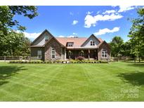 Charming exterior showcasing stone accents, manicured lawn, and inviting front porch at 114 Wingard Rd, Concord, NC 28025