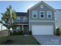 Charming two-story home featuring a two-car garage and a well-manicured front lawn on a sunny day at 120 Mooring Dr, Statesville, NC 28677