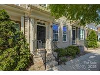 Charming brick townhouse with a black front door, trimmed bushes and well-manicured front yard at 1225 Assembly St, Belmont, NC 28012