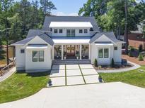 Inviting two-story home with a manicured lawn, modern driveway, and a charming covered porch at 135 Holt Ln, Mooresville, NC 28117