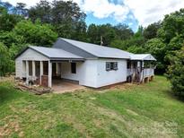 Charming single story home with white siding, metal roof, covered entry, and lush green lawn at 140 Dalu Ln, Harmony, NC 28634