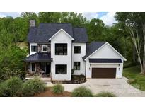 Beautiful modern farmhouse with black roof, white siding, and black trim, plus manicured landscaping at 1543 Withers Dr, Denver, NC 28037
