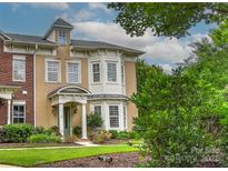 Charming home boasts a mix of brick and stucco, complemented by lush greenery and a well-manicured lawn at 17210 Sulky Plough Rd # 1206, Charlotte, NC 28277
