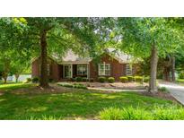 Charming red brick home featuring a well-maintained lawn and mature trees, enhancing curb appeal at 2005 Schofield Pl, Salisbury, NC 28144