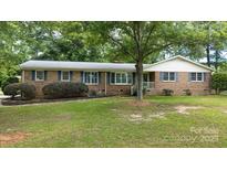 Charming brick home featuring blue shutters, lush landscaping, and a welcoming front porch at 2618 Pineview Dr, Lancaster, SC 29720