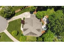 Stunning aerial view of the roof, driveway, and lush landscaped backyard with patio and jacuzzi at 3009 Botetourt Ct, Weddington, NC 28104