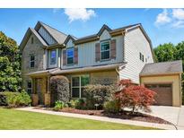 Two story home with a brick and vinyl exterior, a two car garage, and manicured landscaping at 3808 Halcyon Dr, Huntersville, NC 28078