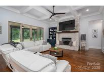 A cozy living room with stone fireplace, large sliding glass door, and comfortable white seating at 4143 Willow Haven Dr, Denver, NC 28037