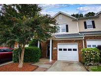 Charming townhome featuring a brick facade, attached garage, and manicured landscaping at 4728 Cottage Oaks Dr, Charlotte, NC 28269