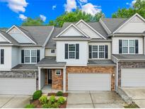 Charming townhome with a two-car garage and brick facade, complemented by beautiful landscaping at 4848 Fonthill Ln, Charlotte, NC 28210