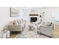 Bright living room features a cozy fireplace, stylish furnishings, and a neutral color palette with natural light at 4905 Chestnut Lake Dr, Charlotte, NC 28227