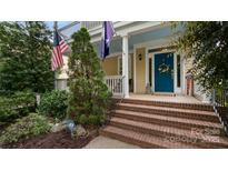Charming home with a welcoming front porch, brick steps, and a vibrant blue door adorned with a wreath at 6129 Caseys Side Way, Fort Mill, SC 29708