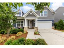 Charming home featuring a landscaped yard, inviting front porch, and a two-car garage at 6261 Six String Ct, Fort Mill, SC 29708