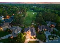 Stunning aerial view of a home near the golf course at sunset, surrounded by lush green trees at 7412 Sahalee Dr, Denver, NC 28037