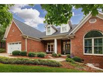 Beautiful brick home featuring manicured landscaping and a charming front porch with stately columns at 8008 Alba Ct, Charlotte, NC 28269