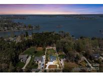 Stunning aerial view showcasing lakefront home with lush landscaping and private waterfront access at 8039 Mcconnell Rd, Denver, NC 28037