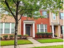 Charming two-story red brick townhouse with well-maintained landscaping and inviting front entrance at 8230 Viewpoint Ln, Cornelius, NC 28031