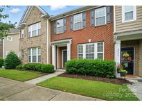 Charming brick townhome with well-manicured front yard and inviting entrance at 8230 Viewpoint Ln, Cornelius, NC 28031