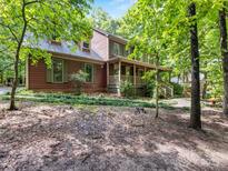 Charming two-story home featuring a full front porch and lush green surroundings at 10710 Bristlecone Ct, Mint Hill, NC 28227