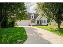 Charming single-Gathering home featuring a manicured lawn, long driveway, and attached two-car garage at 1083 Elljoy Ln, Salisbury, NC 28146