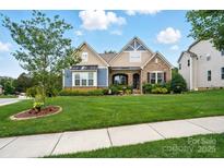 Well-maintained home with lush green lawn, mature landscaping, and partial tree coverage at 10903 Skymont Dr, Huntersville, NC 28078