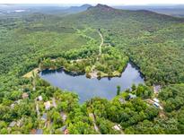 Breathtaking aerial view of a lake community nestled in lush green surroundings with a mountain backdrop at 1102 Lake Montonia Rd, Kings Mountain, NC 28086