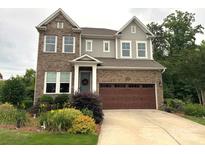 Charming two-story home featuring a brick facade, well-manicured lawn, and a welcoming front entrance at 1124 Greenbridge Dr, Matthews, NC 28105