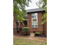 Charming brick townhome with awning and landscaped yard at 129 Steinbeck Way, Mooresville, NC 28117