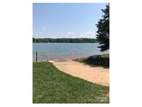 Scenic view of a lake with a sandy beach and clear blue water on a sunny day at 134 Crystal Cir, Mooresville, NC 28117